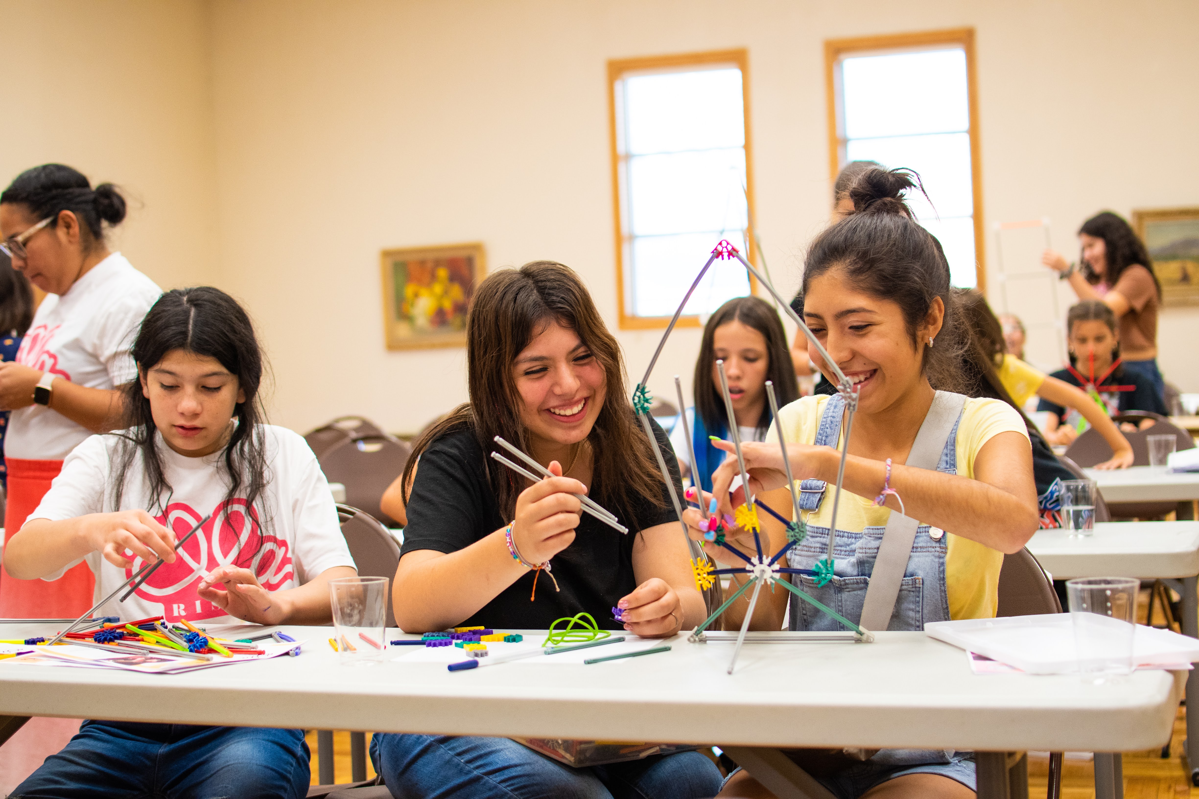 Young women participating in a STEM workshop, engaging with technology and learning